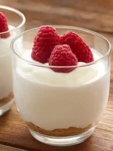 Vasitos de tarta de queso con frambuesas, un postre fácil y elegante.