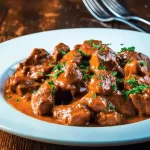 Mollejas de pollo en salsa servidas en un plato con guarnición.