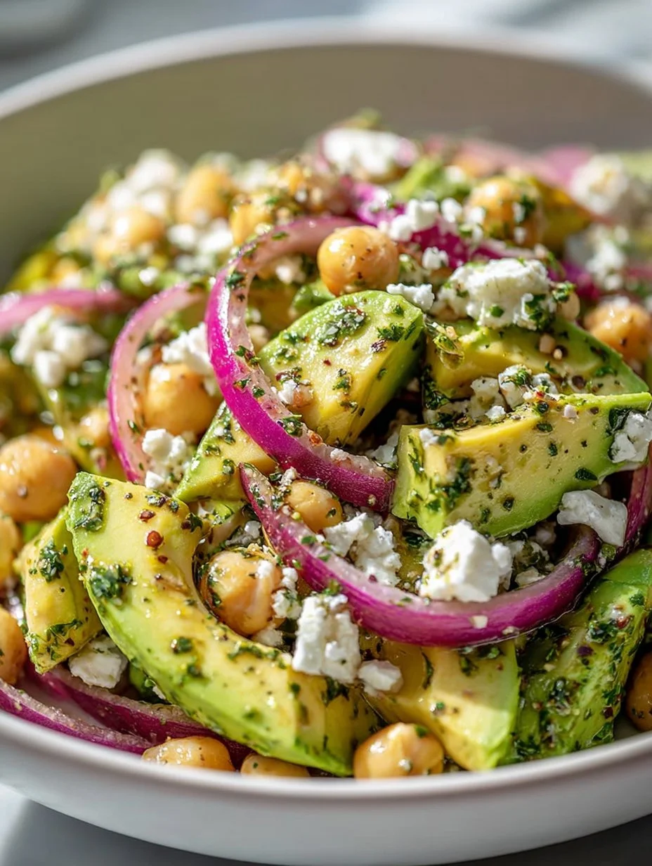 Ensalada de garbanzos con queso feta y aguacate en un plato colorido