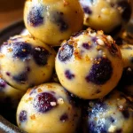 Bocaditos de proteína de requesón con limón y arándanos en un plato fresco