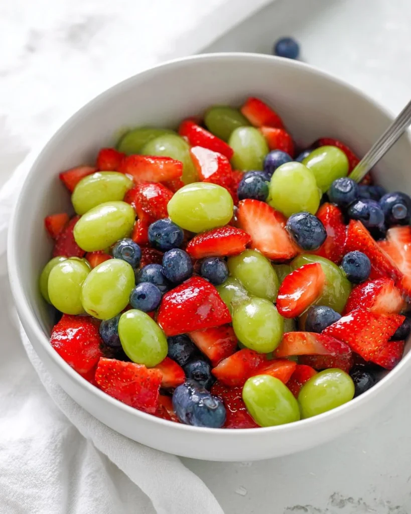 Ensalada de frutas colorida con miel y lima servido en un bowl