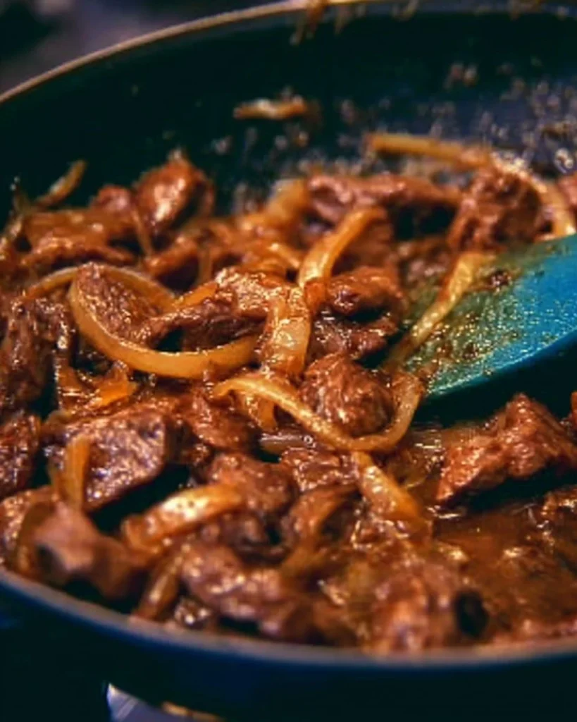Plato de hígado encebollado servido con cebolla caramelizada.
