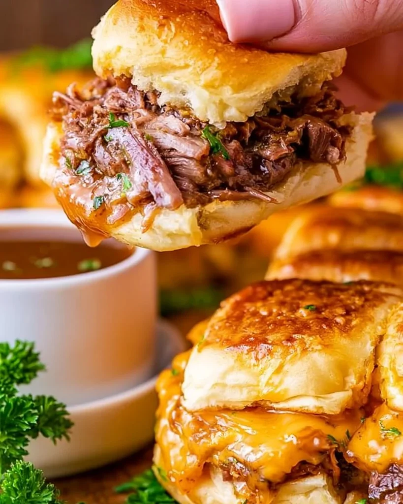 Deslizadores de French Dip jugosos y sabrosos servidos con salsa para mojar.