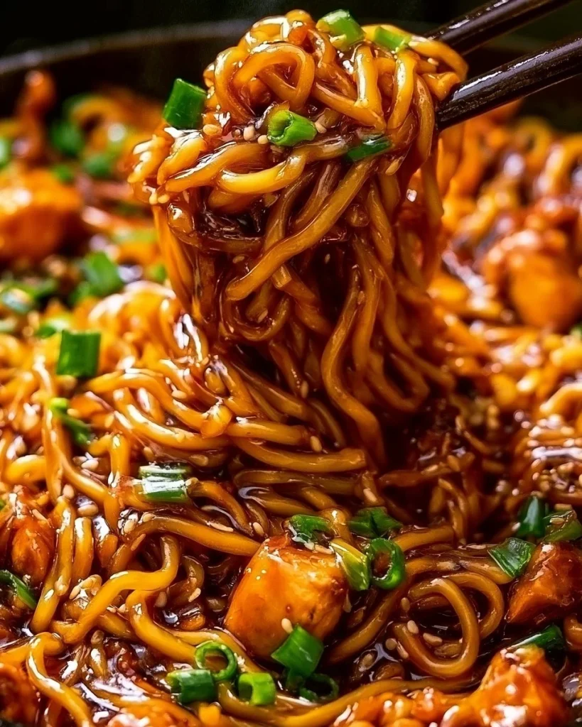 Pollo en salsa de ajo pegajosa servido con fideos