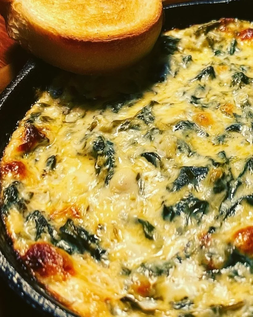 Dip vegano de espinacas y alcachofas servido en un plato.