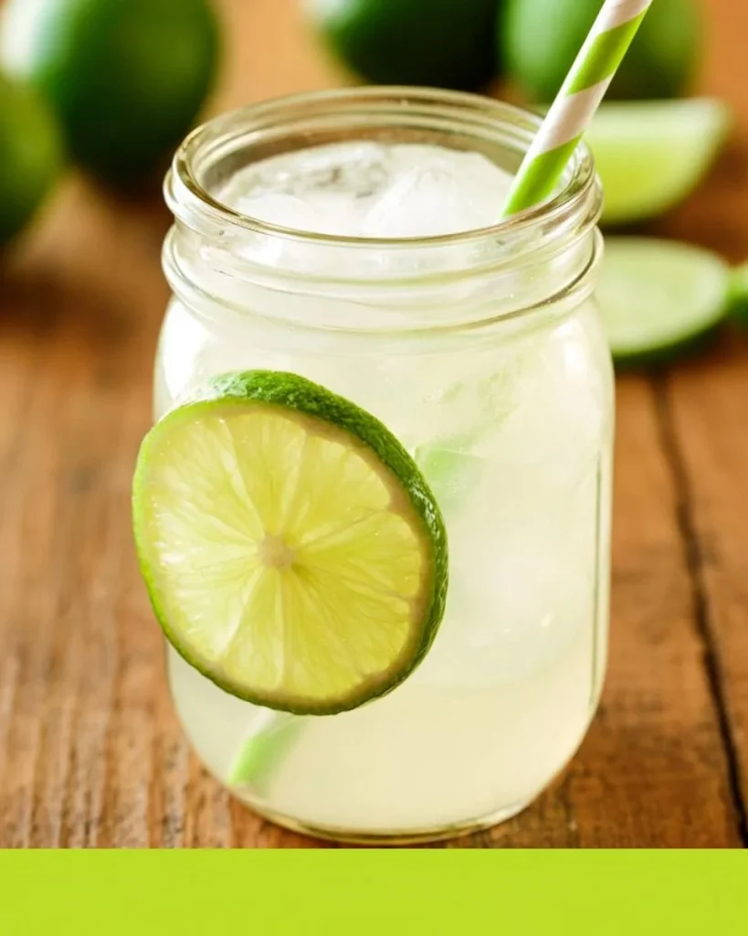 Un vaso de limonada fresca decorado con rodajas de limón y hojas de menta.