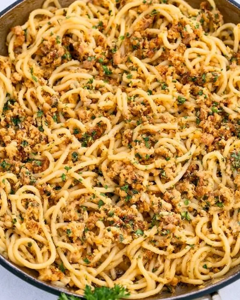 Plato de pasta de sardinas con limón y migas de ajo, presentación apetitosa.