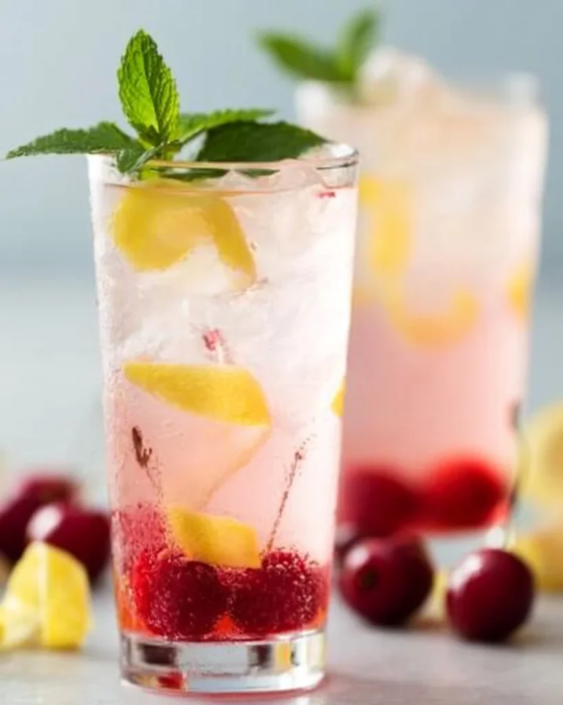 Agua infusionada de cereza con limones en un vaso refrescante