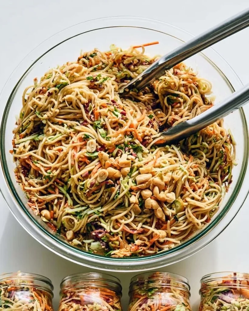 Ensalada de fideos con aderezo de mantequilla de maní en un plato colorido.