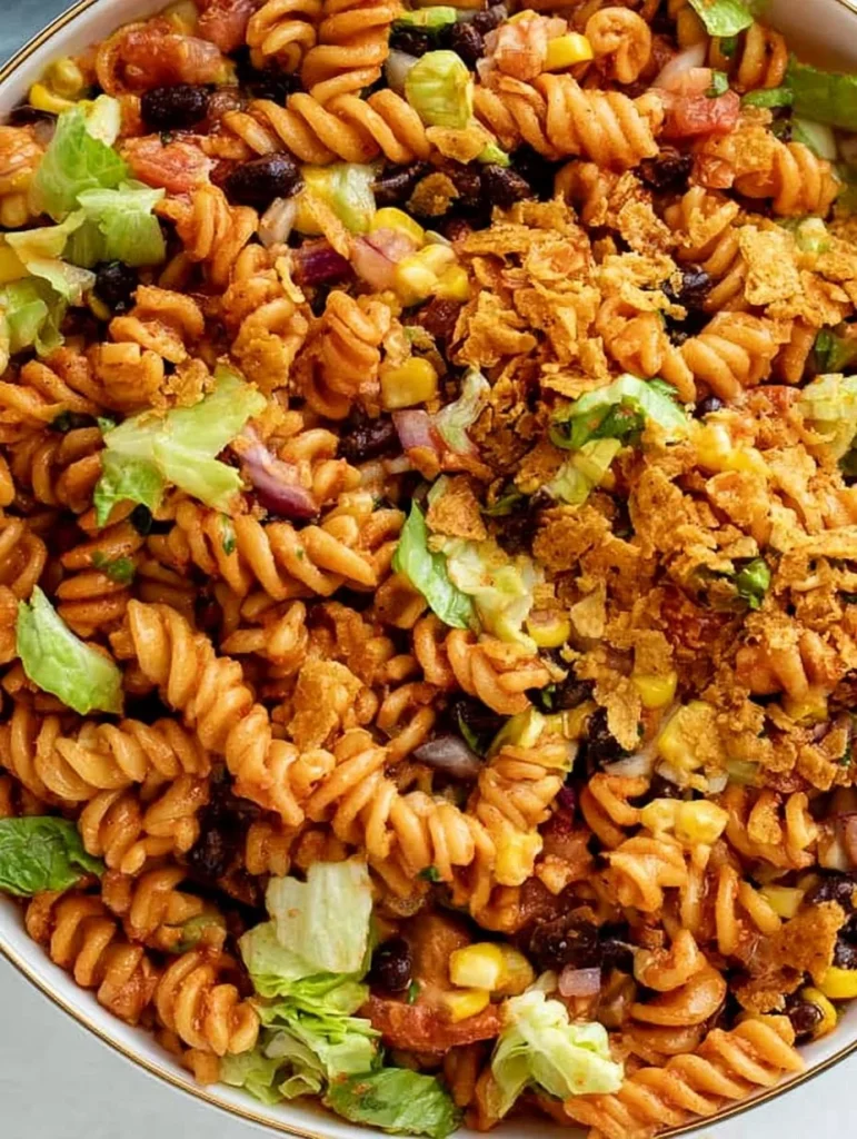 Ensalada de pasta con tacos presentada en un plato colorido y fresco.