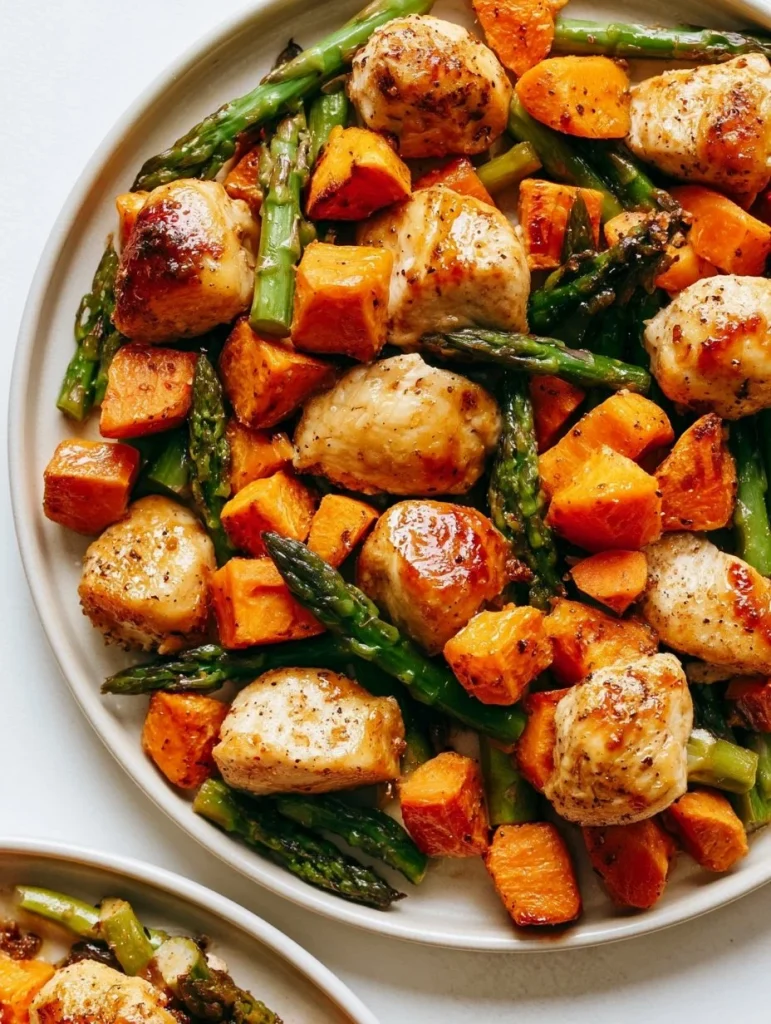 Plato de pollo saludable con batatas asadas y vegetales frescos.
