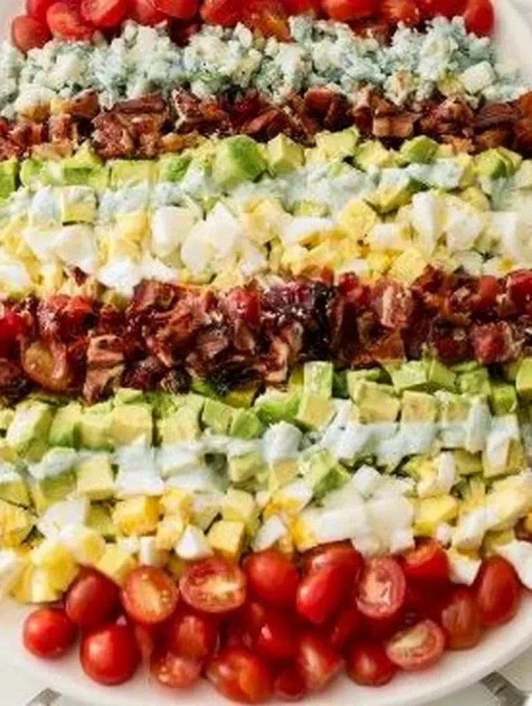 Ensalada Cobb de pollo con tocino crujiente y queso azul en un plato.
